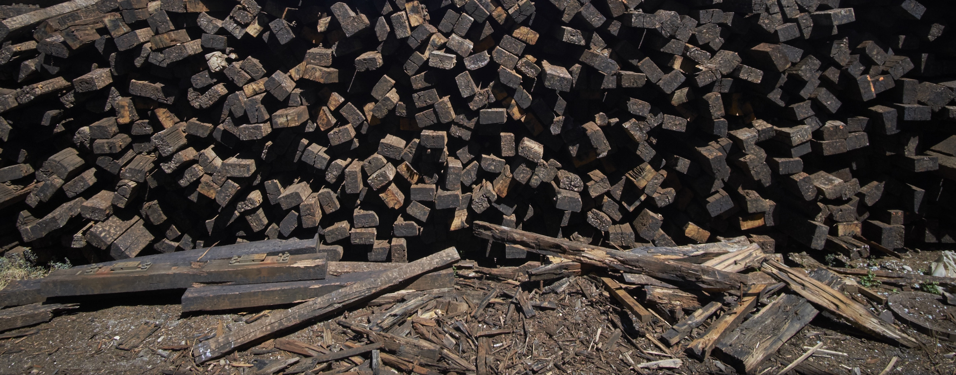 Stockpile of creosote-treated wooden railway sleepers awaiting decontamination